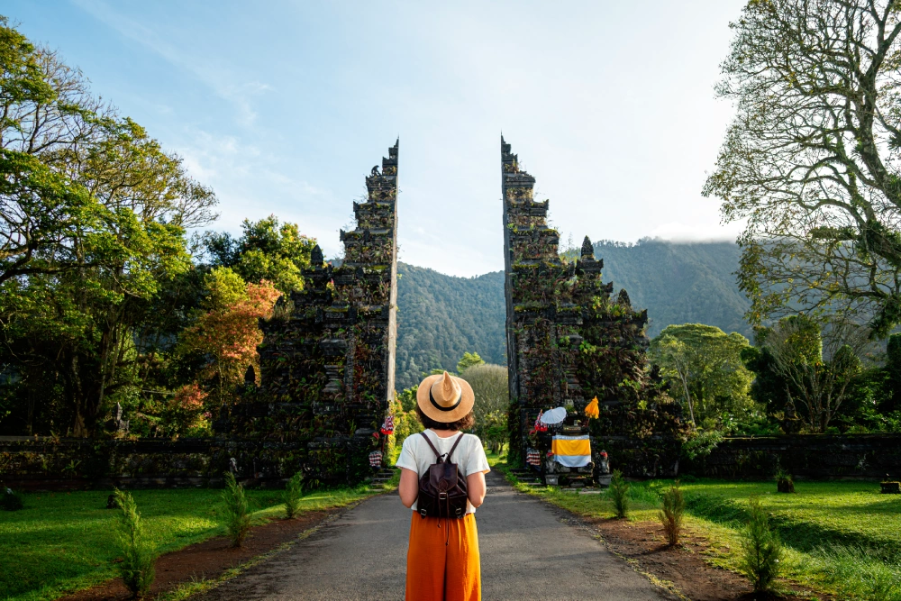 A person standing in front of an entrance to a park.