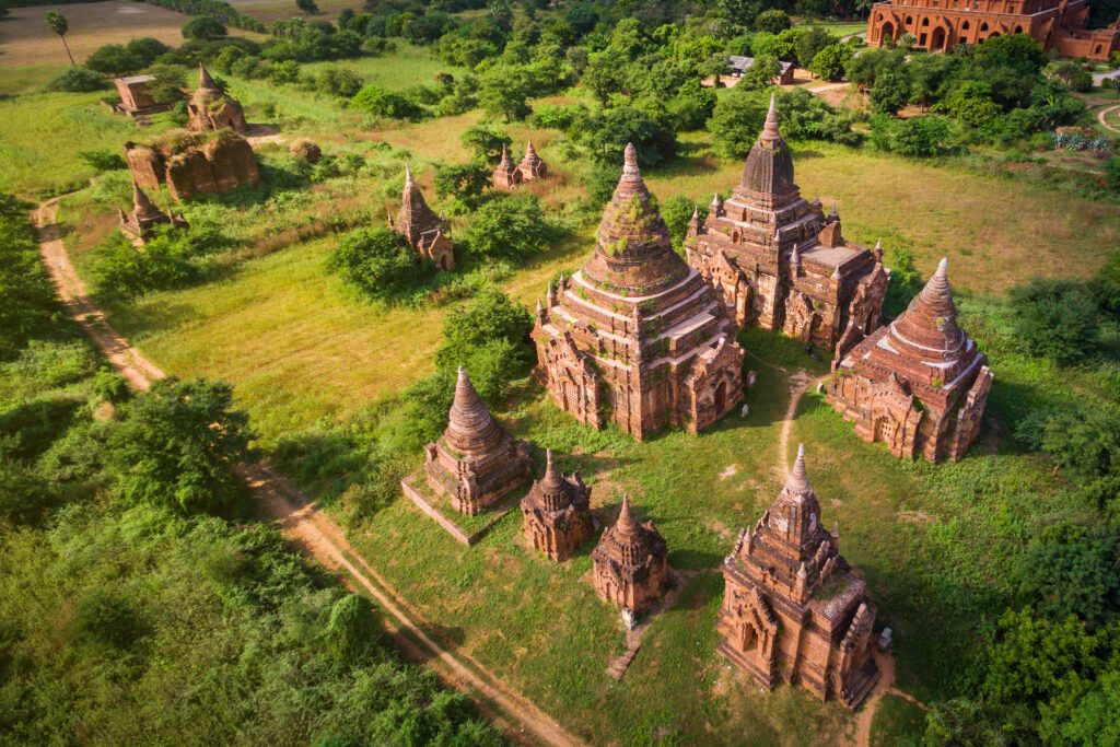 An aerial view of a group of temples in the middle of a field.