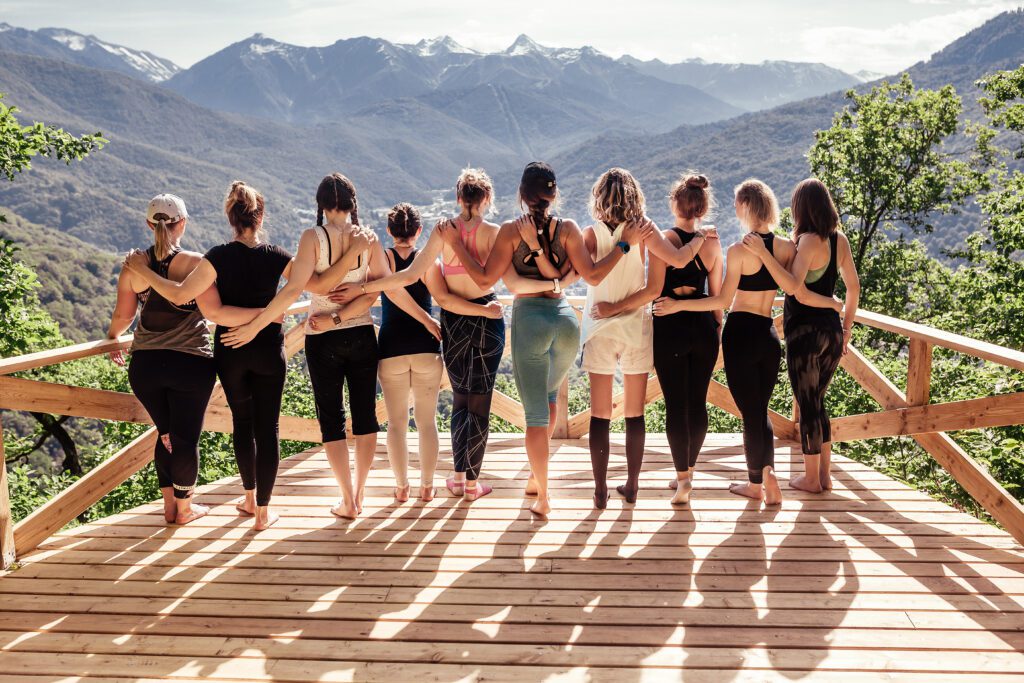 A group of women standing on top of a wooden deck.