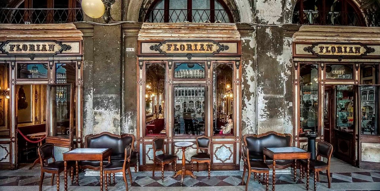 Outdoor café seating at Caffè Florian with views of St. Mark’s Basilica. Outdoor café seating at Caffè Florian with views of St. Mark’s Basilica.