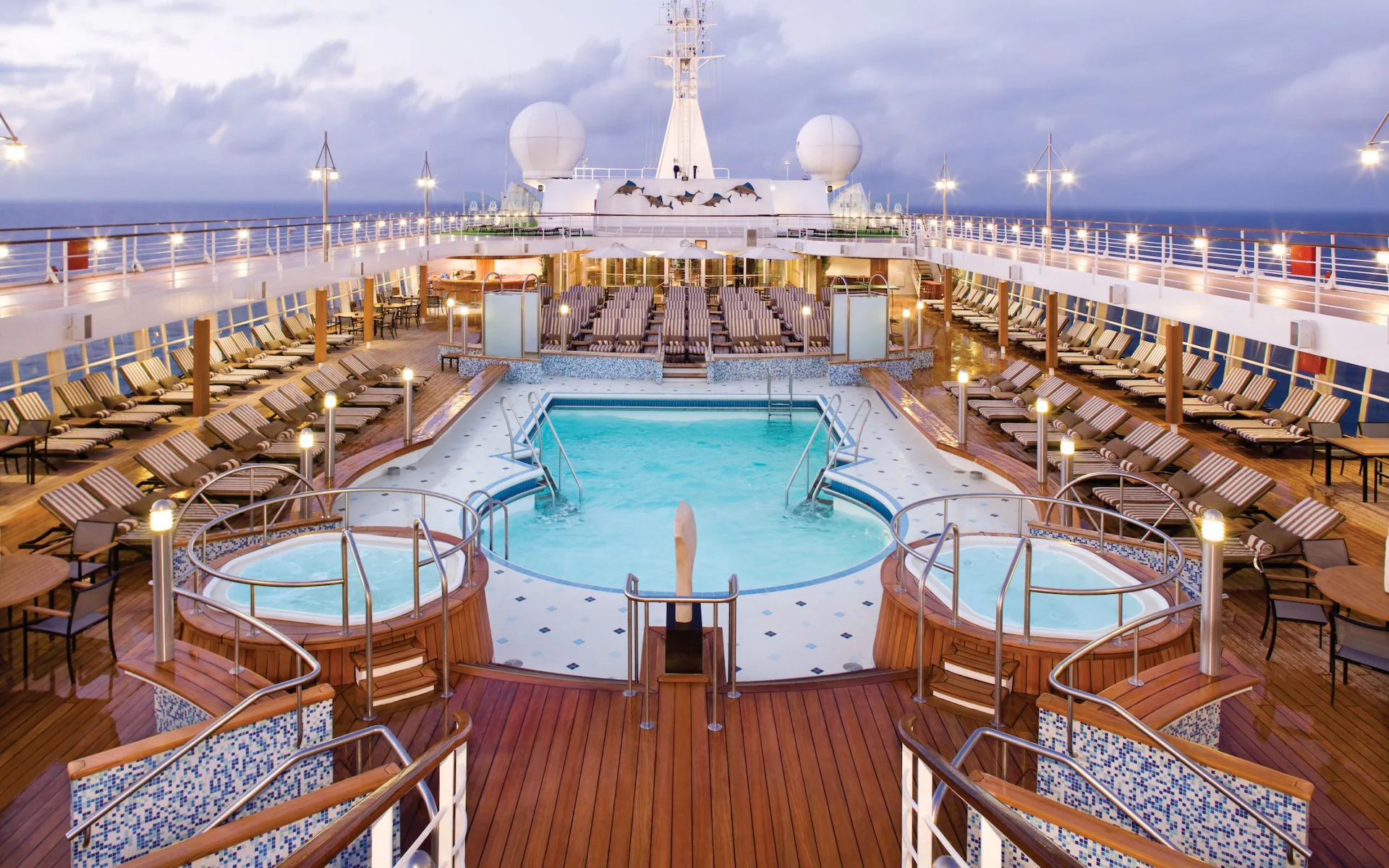 TELEMMGLPICT000003379122_17268473412880_trans_NvBQzQNjv4BqpVlberWd9EgFPZtcLiMQf0Rf_Wk3V23H2268P_XkPxc Cruise ship pool deck with hot tubs.