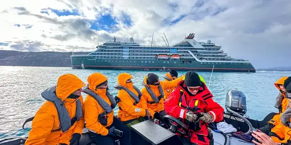 qt=q_63 Passengers in orange suits on a cruise ship excursion.