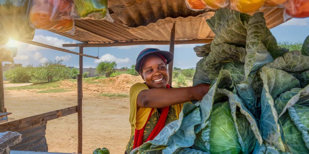 rs=w_1200,h_600,cg_true (5) Smiling woman selling cabbages at market.