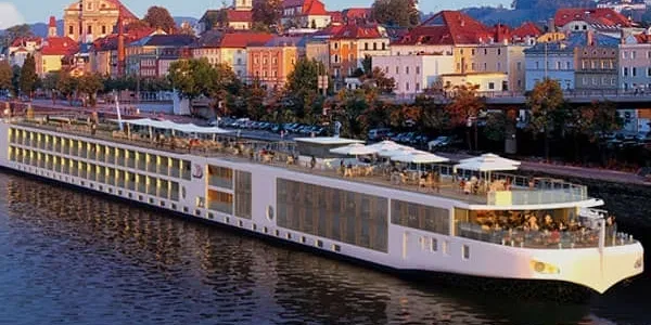 rs=w_600,h_300,cg_true River cruise ship docked by city.